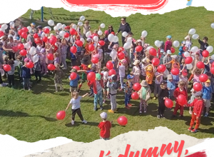 plakat Dzień flagi w Przedszkolu 424. Dzieci z biało-czerwonymi balonami ustawiły się grupą, tworząc flagę Polski